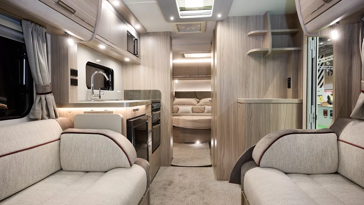 Elddis Crusader Aurora interior, beige/brown upholstery, wooden furniture, lounge, kitchen, bedroom, fixed island bed, three skylights