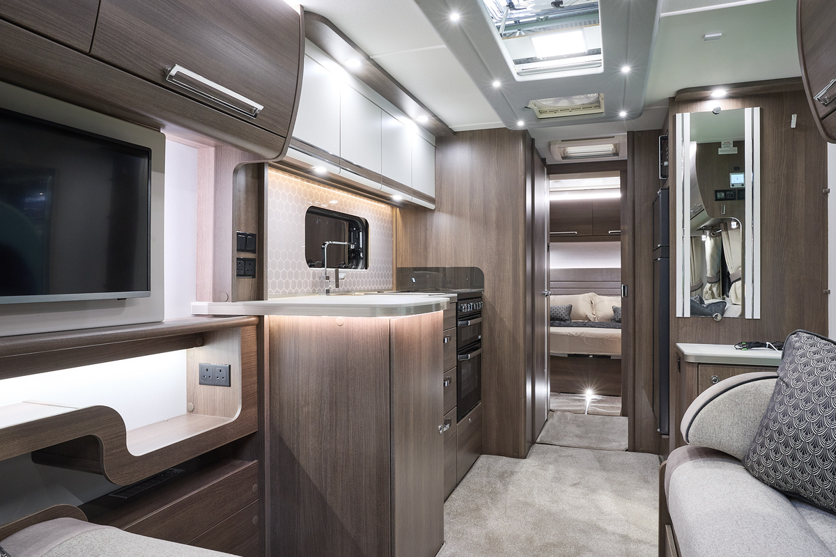 Buccaneer Barracuda interior, cream upholstery, dark wood furniture, white kitchen overhead lockers, lounge, kitchen, bedroom, fixed bed, three skylights