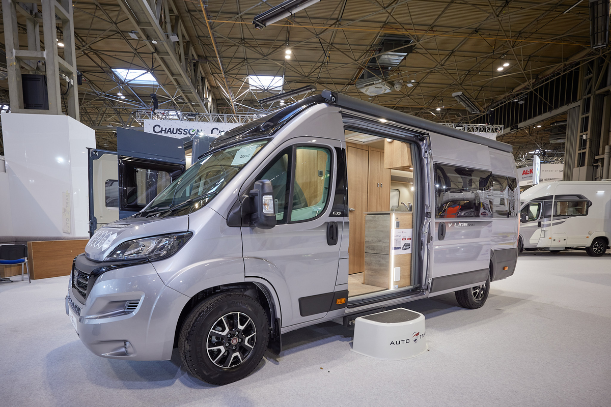 Auto-Trail V-Line 635 Sport has a silver exterior.  The sliding door is open showing the interior, with a  step to gain easy access.