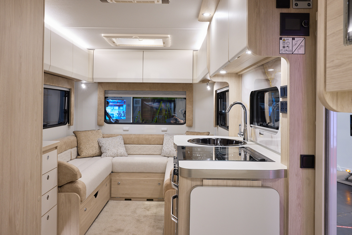 The Elddis Avalon 295 has beige carpets and cream cabinets.  The upholstery is cream and pale brown.  The kitchen is placed in the middle and just behind there is a u shaped lounge.  There is a skylight above the lounge.