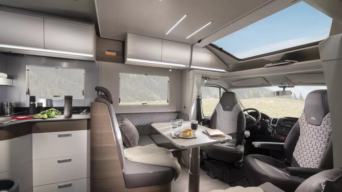 The Adria Matrix Supreme 670 SC has brown and beige upholstery, it has matching cabinets.  The front seats are swivelled and join the dining area.  There is a huge sunroof above the cab.