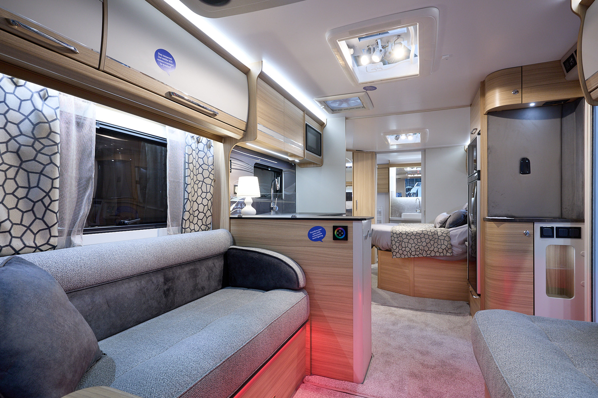 Bailey Alicanto Grande Evora interior, grey upholstery, wooden furniture, cream/wood overhead lockers, pink ambient lighting, two skylights
