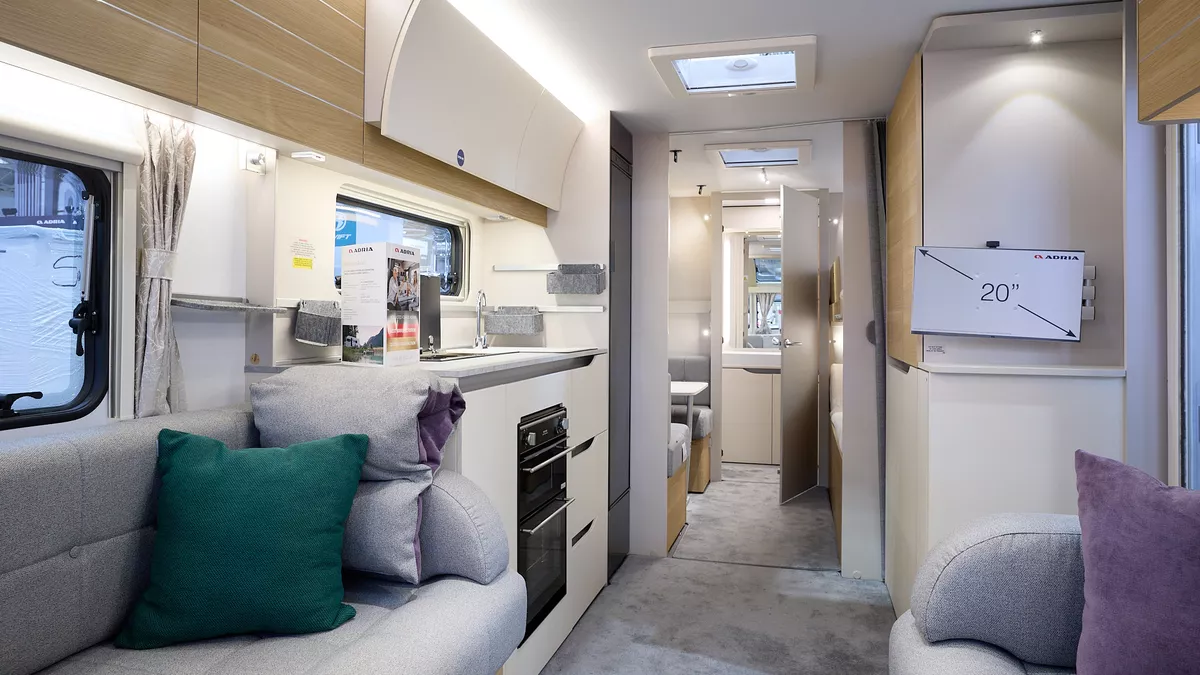 Adria Adora 623 DT Sava, interior, grey interior, white lockers, wooden overhead lockers, lounge, kitchen,green cushion, purple cushion