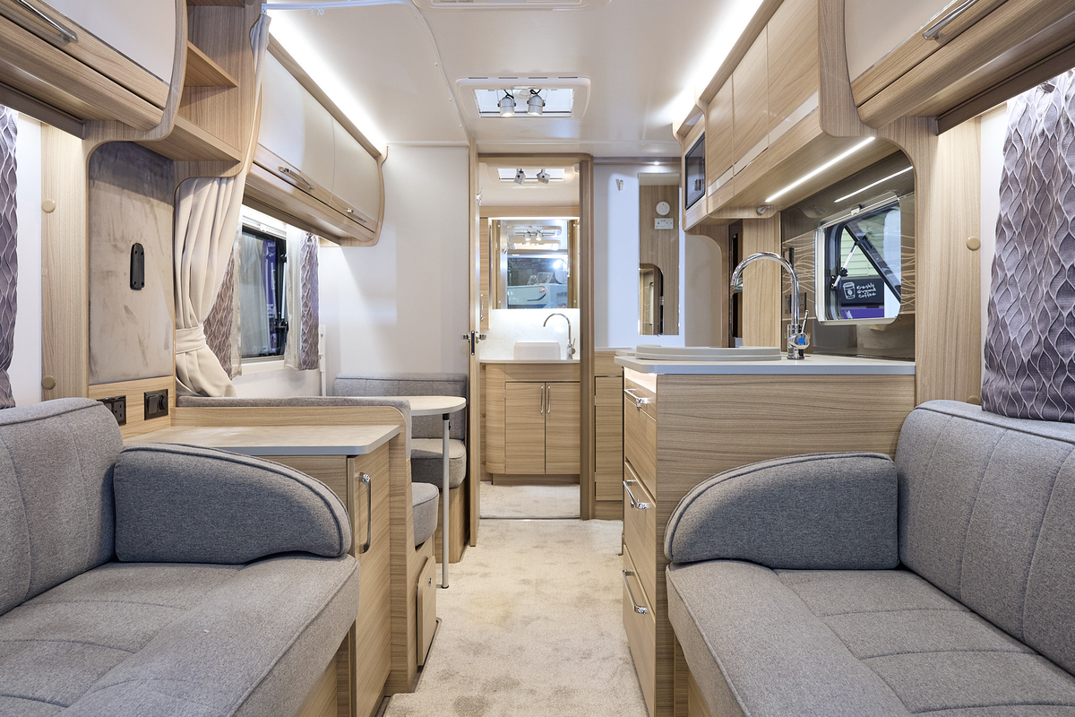 Bailey Unicorn Madrid interior, grey upholstery, cream/wood overhead lockers, light wood furniture, lounge, kitchen, dinette, washroom, three skylights