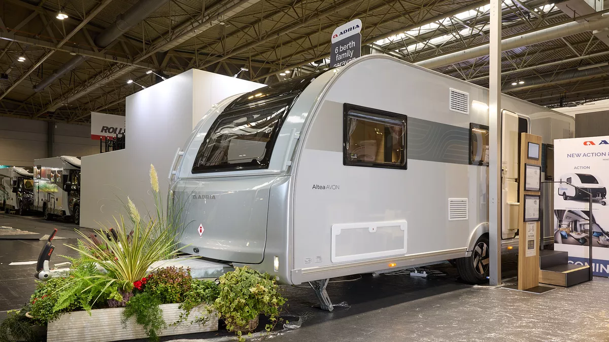 The Adria Altea Avon is silver and grey, complete with nearby plants and hanging signage, emphasising its contemporary design and outdoor comfort features.