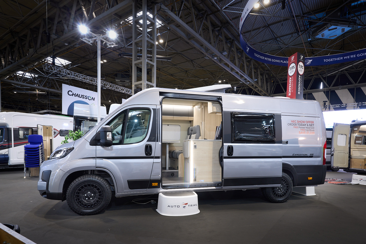 The Auto-Trail Expedition 68 is silver with black decals.  There is a white step by the open sliding door which reveals the interior.  