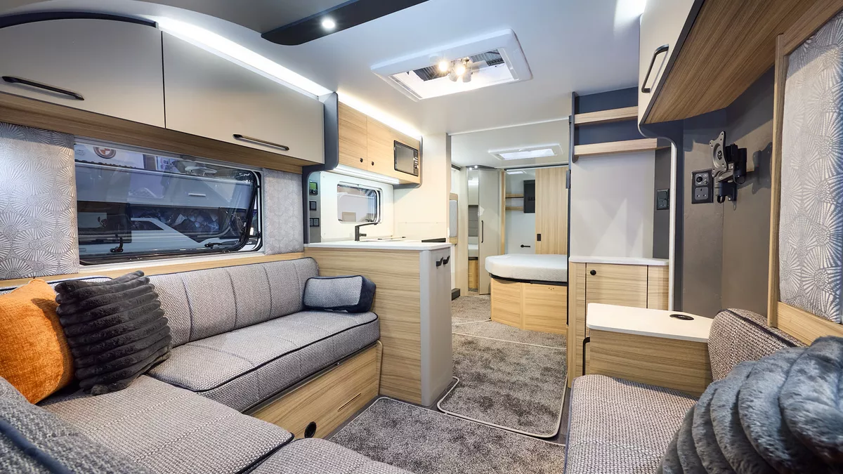 Interior of the Bailey Pegasus Black Bologna with grey sofas in a u-shape, cosy cushions and wood accents, large windows and two skylights will let natural light flood in.  Perfect for relaxation and designed for comfort.