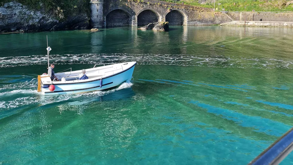 small boat moving through crystal clear water