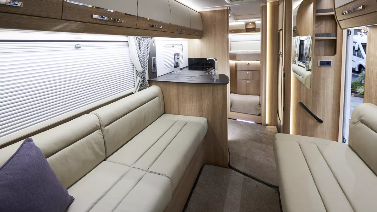 Interior, cream sofas, wood cupboards, purple cushion