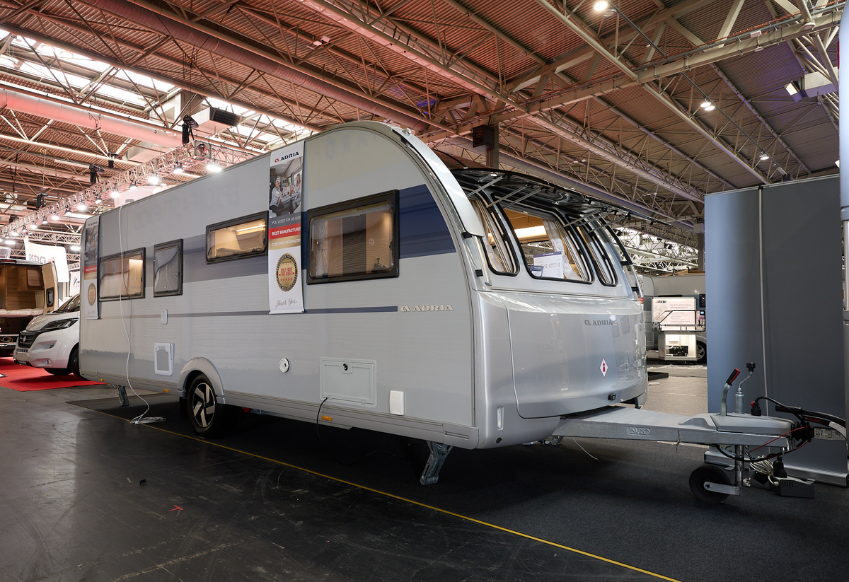 Adria Adora Tiber’s exterior, silver with a blue decal along round the side window.  The front windows are open.  