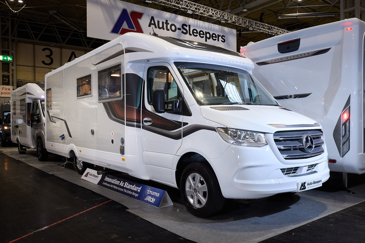 The Auto-Sleeper Burford has a white exterior with a cream inset and bronze/brown decals.  