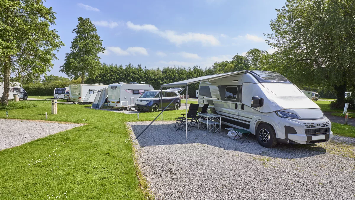 Spacious hardstanding pitches occupied by motorhomes, a campervan and caravans