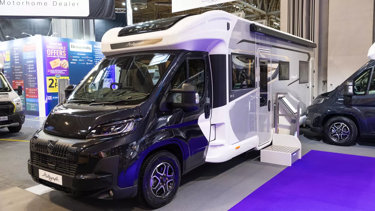 The Bailey Autograph 81-5 has a black cab with a white and grey coachbuilt body.  It has a step next to the habitation door.