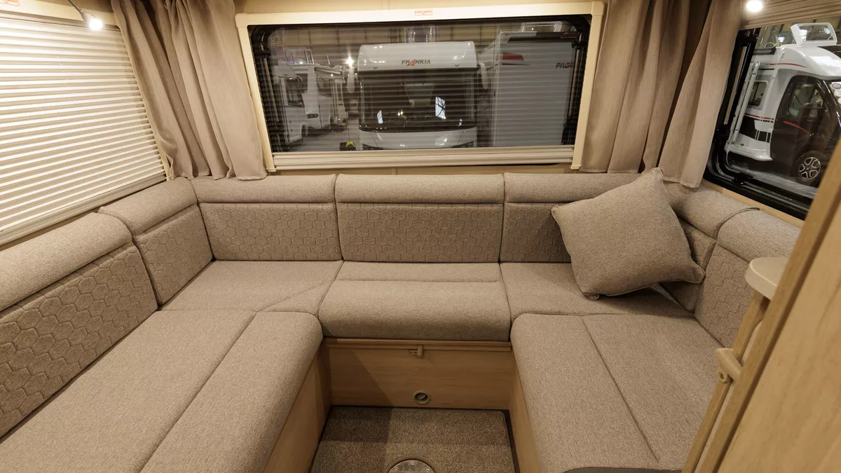 The Auto-Trail Expedition C72 has brown upholstery and has a u shaped sofa in its rear lounge.  This has three large windows with blinds and curtains.