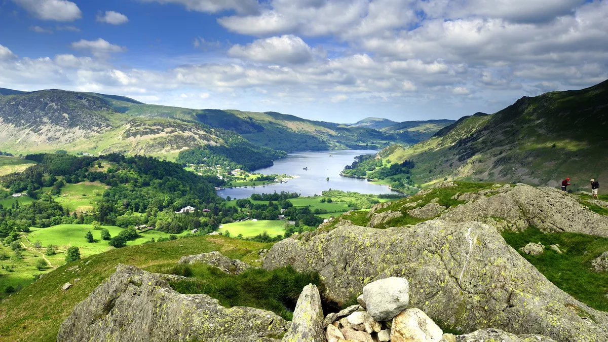 The blue water of Ullswater nestled in the green hills of the Lake District