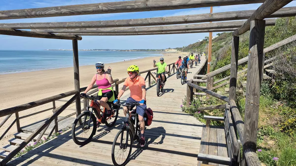 group cycling along the beachfront in the sun