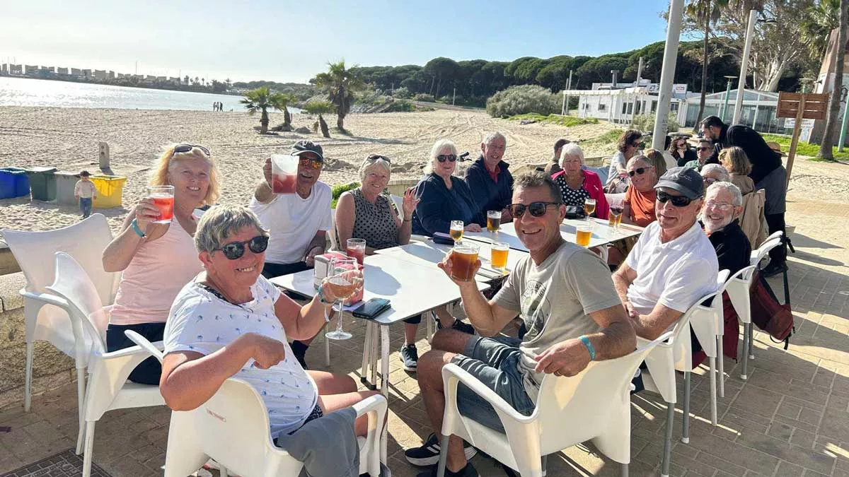 the group around the table enjoying drinks outside