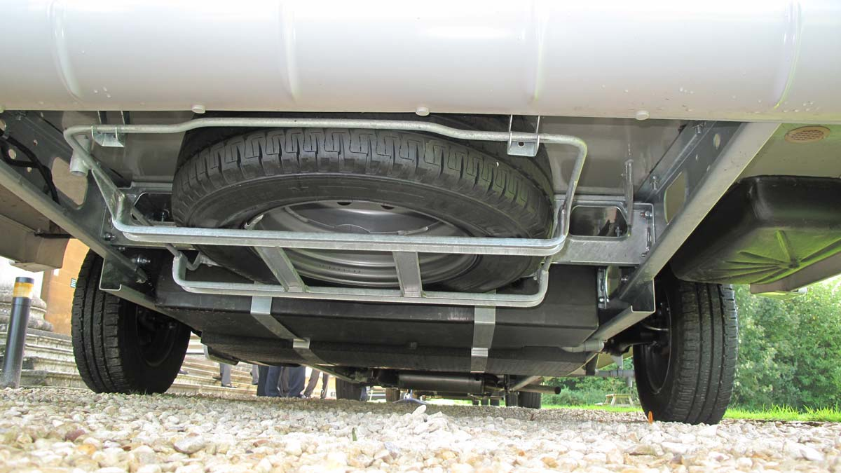 the underside of a motorhome showing the spare tyre