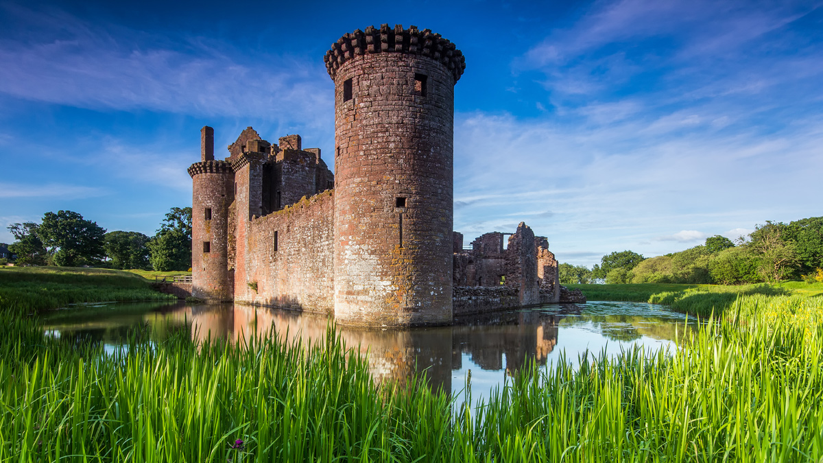 Caerlaverock Castle with its twin towers over the wide moat, Dumfries