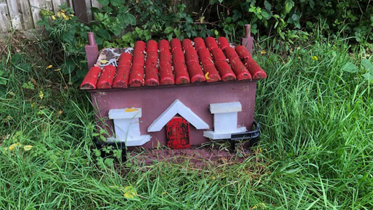Mini cottage for tiny creatures sitting on the grass