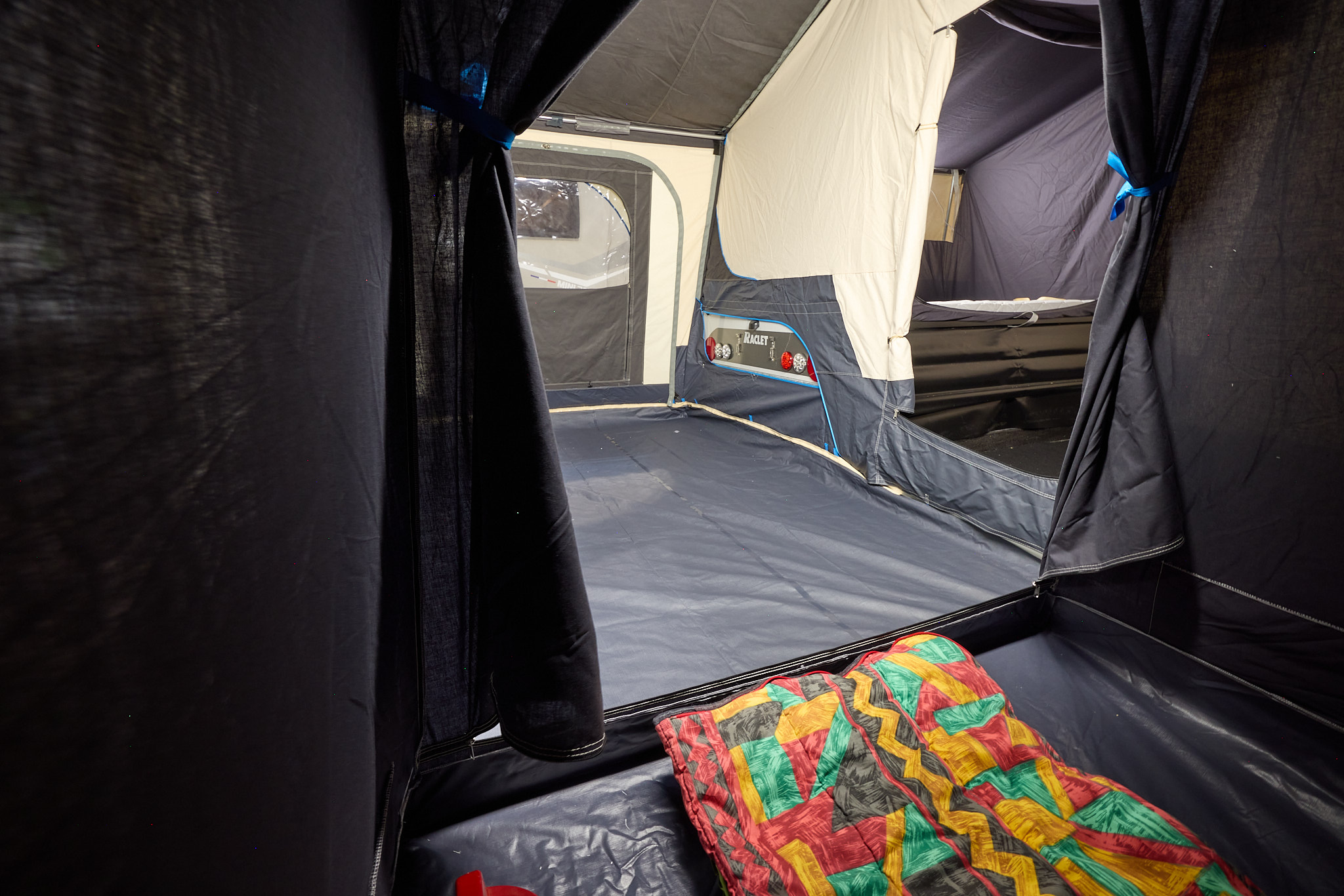 The Raclet Solena 2.1 has an annex with black walls and waterproof flooring.  There is a brightly coloured blanket on the floor.