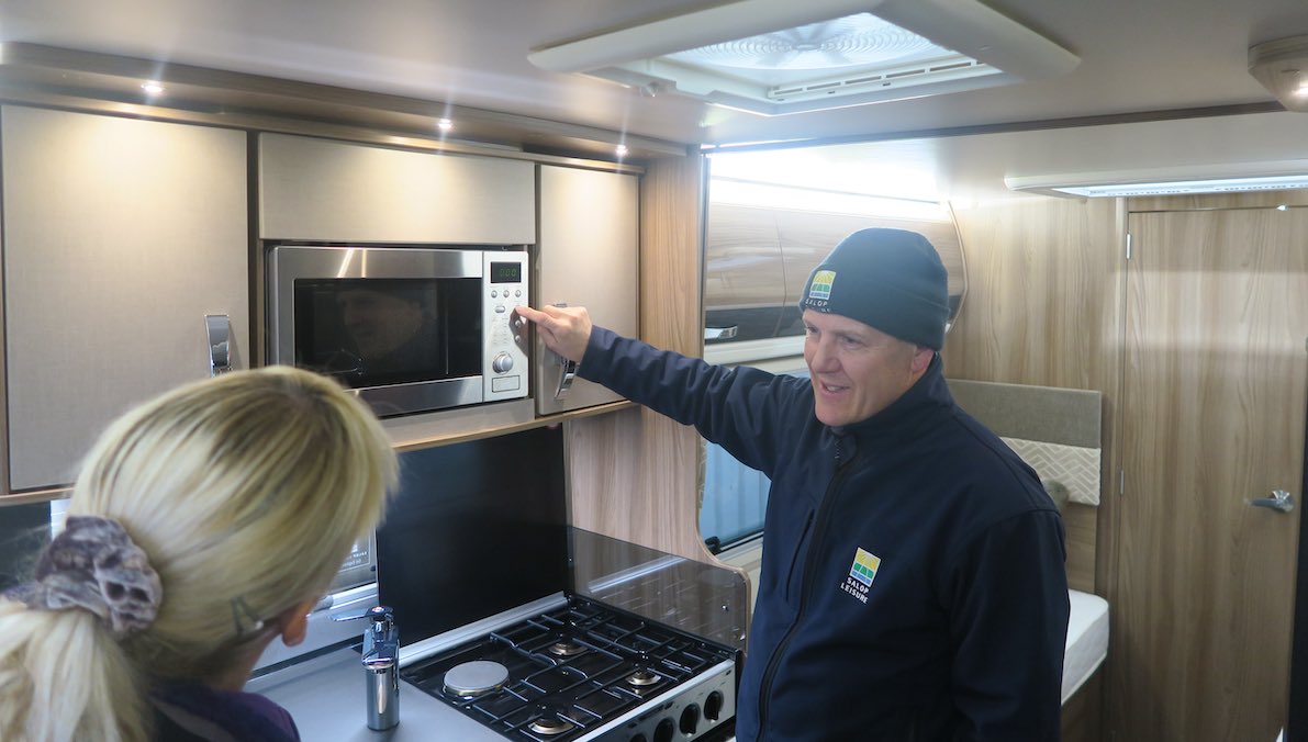 Caravan dealer showing how to use a microwave