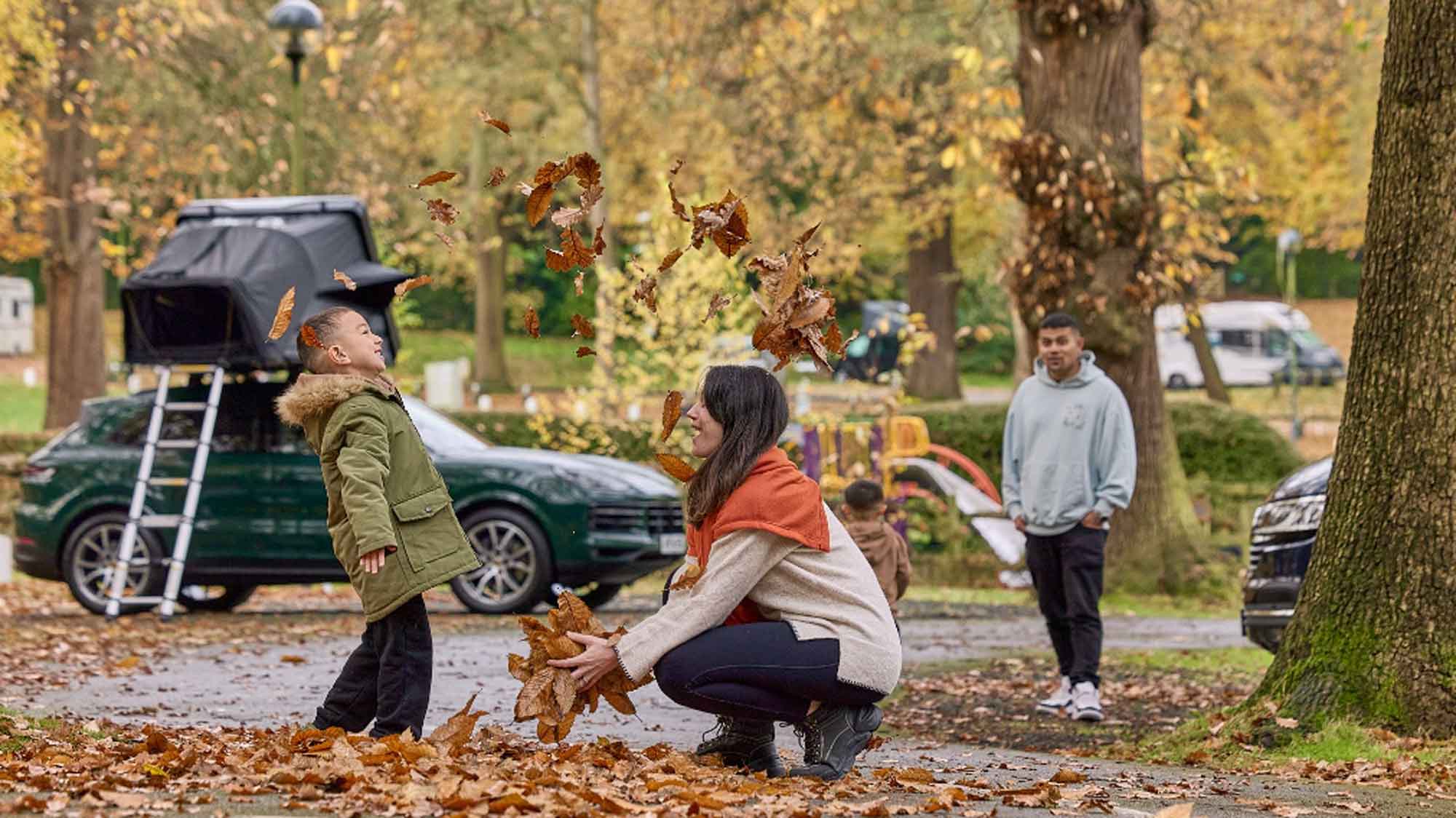 A boy looking up as a women throws leaves in the air