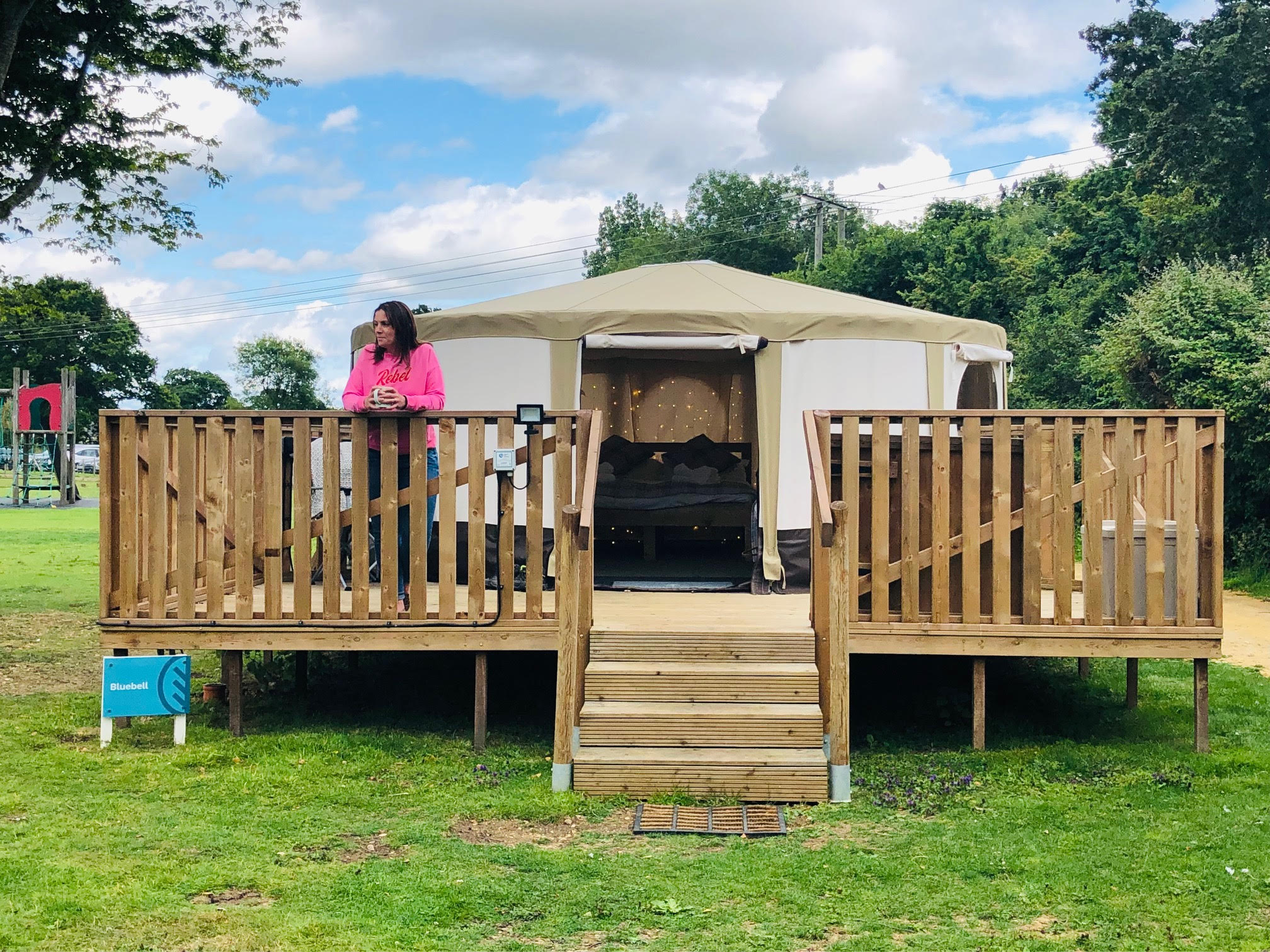 Female on yurt deck, surrounded by peaceful scenery