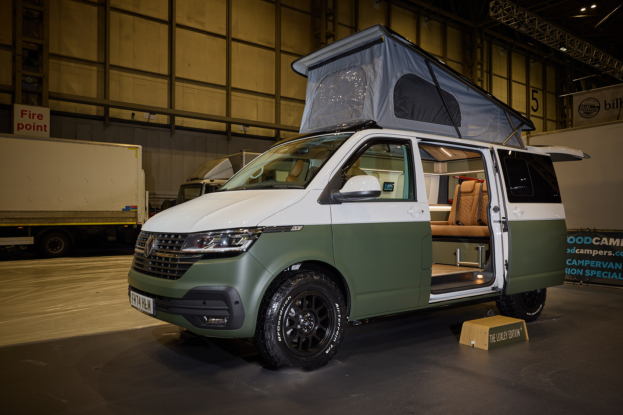 Sherwood Campers Ltd Loxley Edition Conversion SWB has a two tone exterior, white and dark green.  There's a step by the open sliding door.  The rising roof is fully extended.