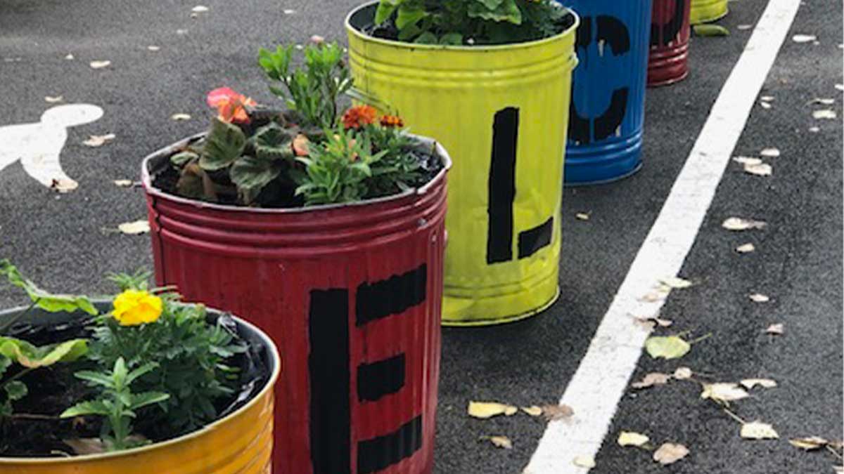 Colourful metal rubbish bins repurposed as flower pots 