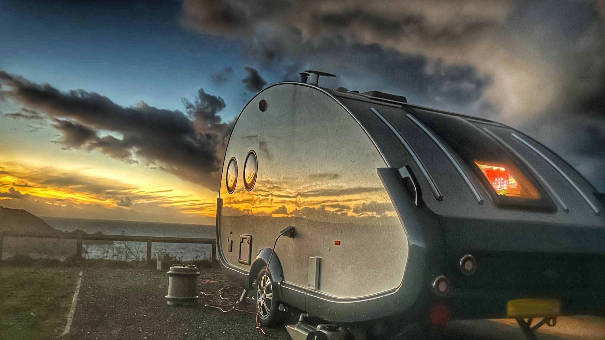 teardrop caravan reflecting the sunset
