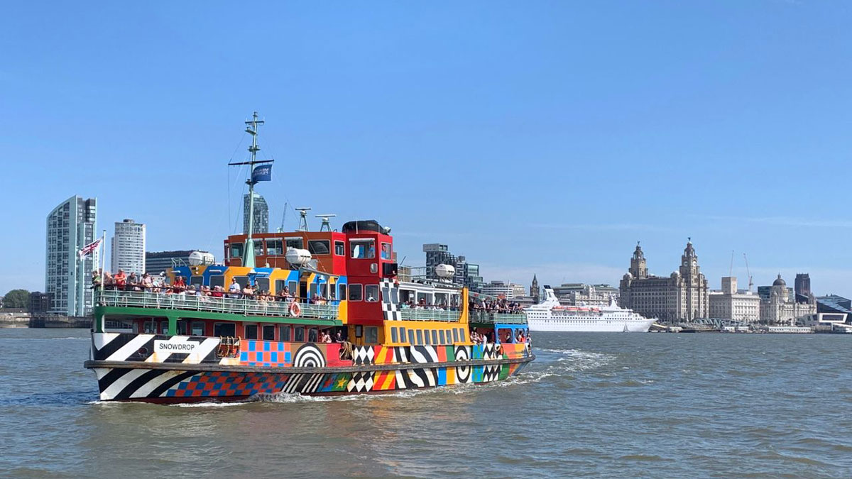 the brightly covered Mersey Ferry making the crossing on a sunny day