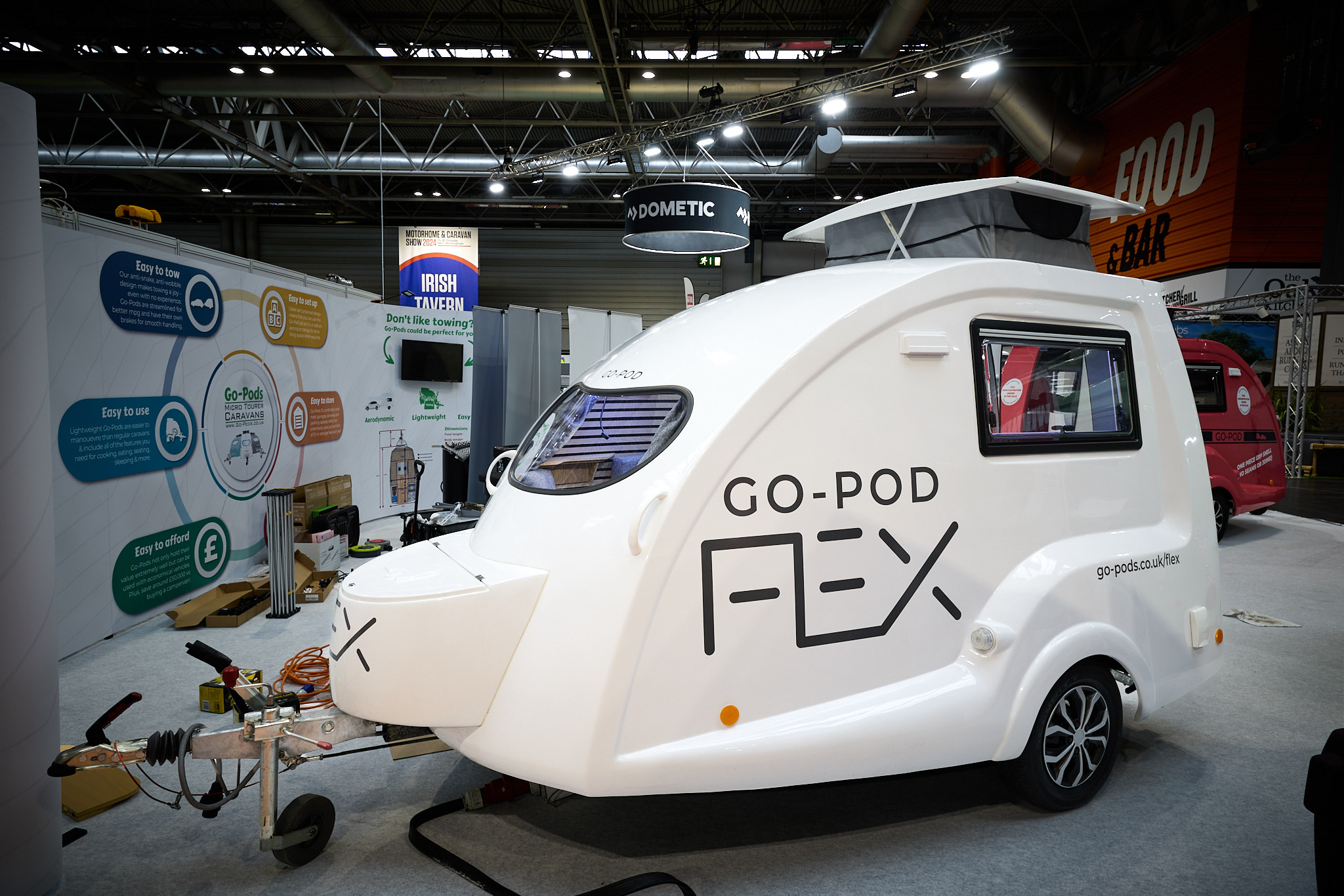 Going Go Pod Flex's exterior is white with its name emblazoned on the side in black.  It's pop top roof is open.