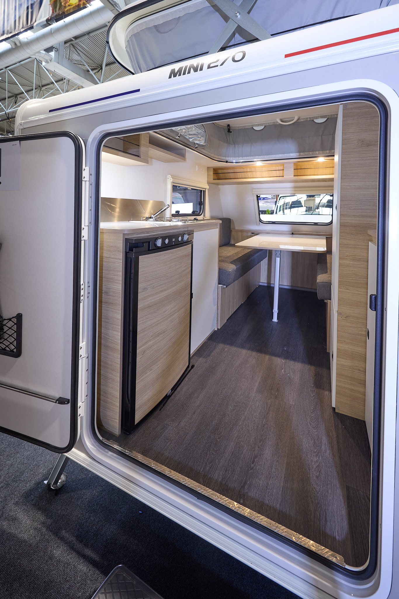 Trigano Mini Freestyle 270's interior is wooden with the kitchen to the left and the seating area to the front
