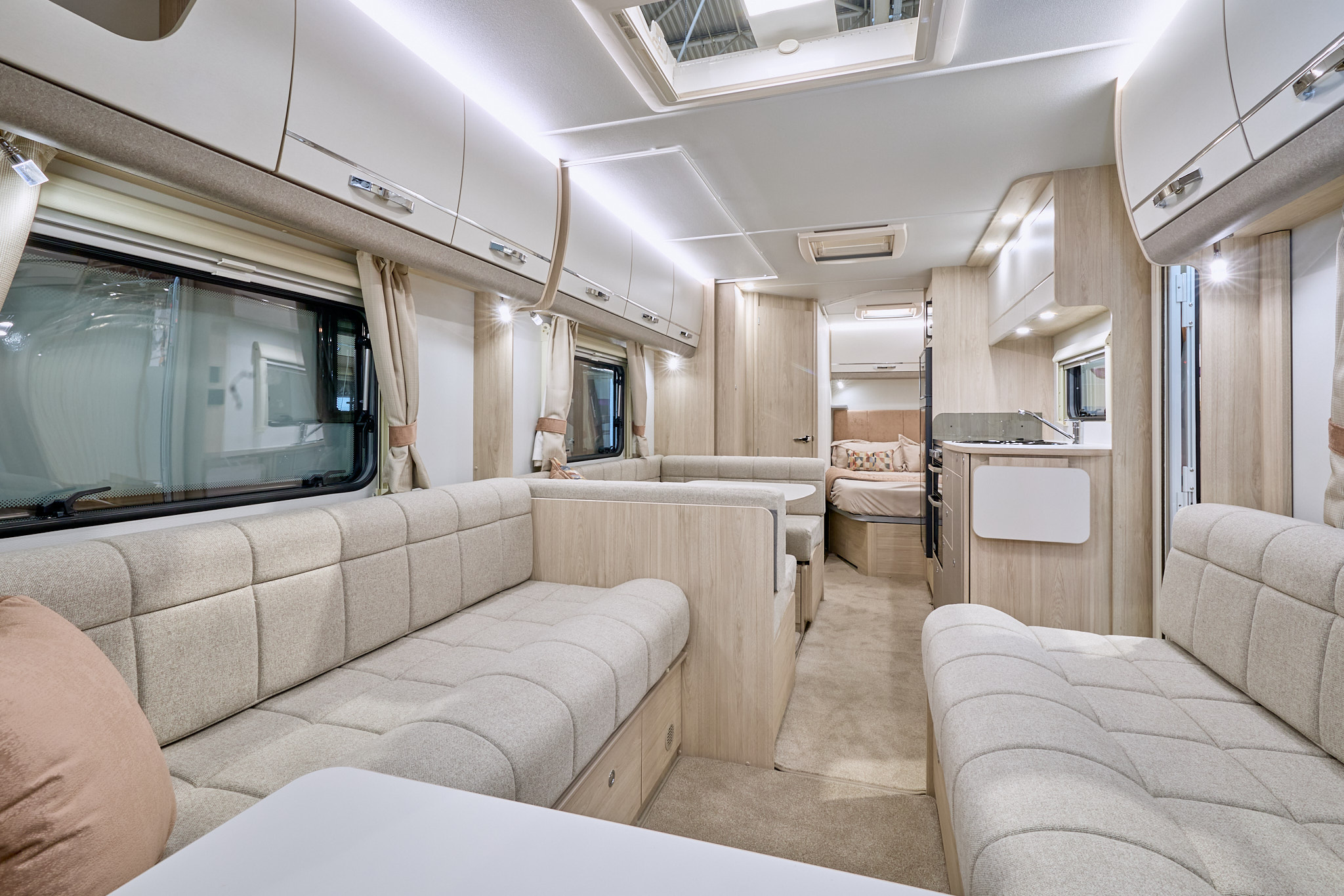 Elddis Avanté 840’s interior has cream upholstery with pale wooden furniture.  The kitchen is in the middle and there’s a dinette opposite.  There is a fixed island bed to the rear