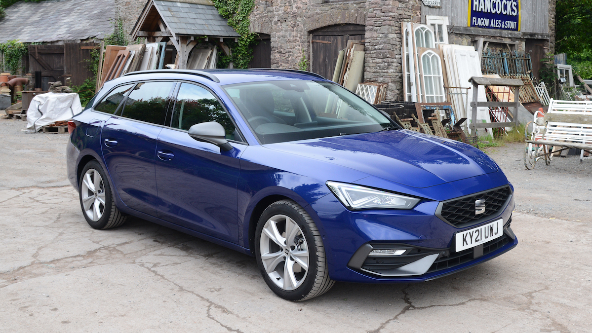 Blue Seat Leon parked in front of a shop