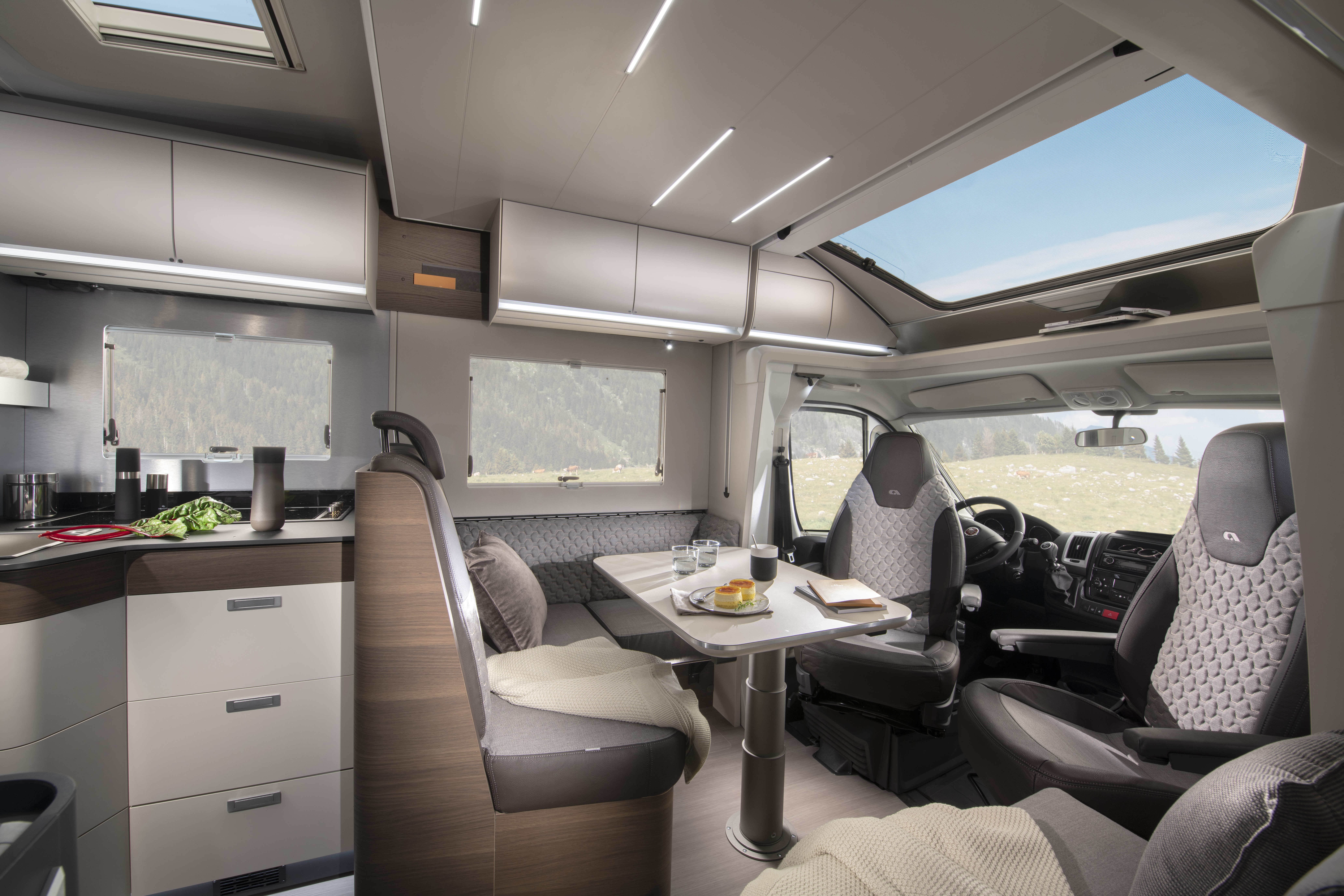 The Adria Matrix Supreme 670 SC has brown and beige upholstery, it has matching cabinets.  The front seats are swivelled and join the dining area.  There is a huge sunroof above the cab.