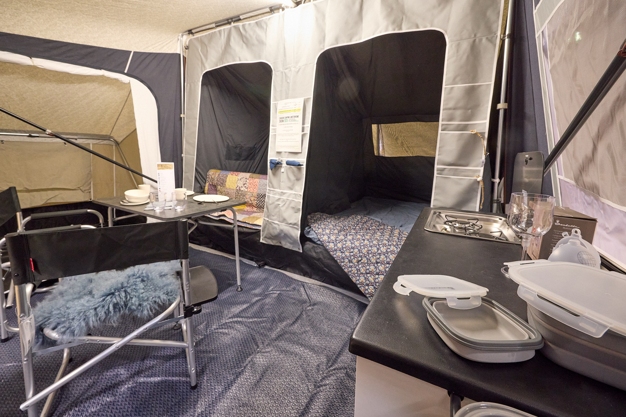 In the Camp-Let North there is a dining table and chairs.  Both bedroom doors are open. The kitchen area is at the front.