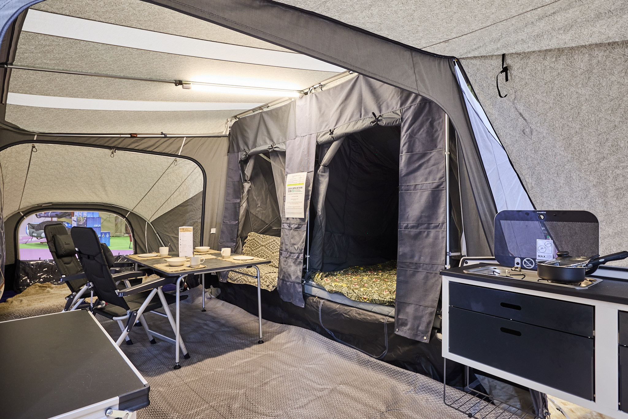 In the Camp-Let Passion there is a dining table and chairs.  Both bedroom doors are open. The kitchen area is at the side.