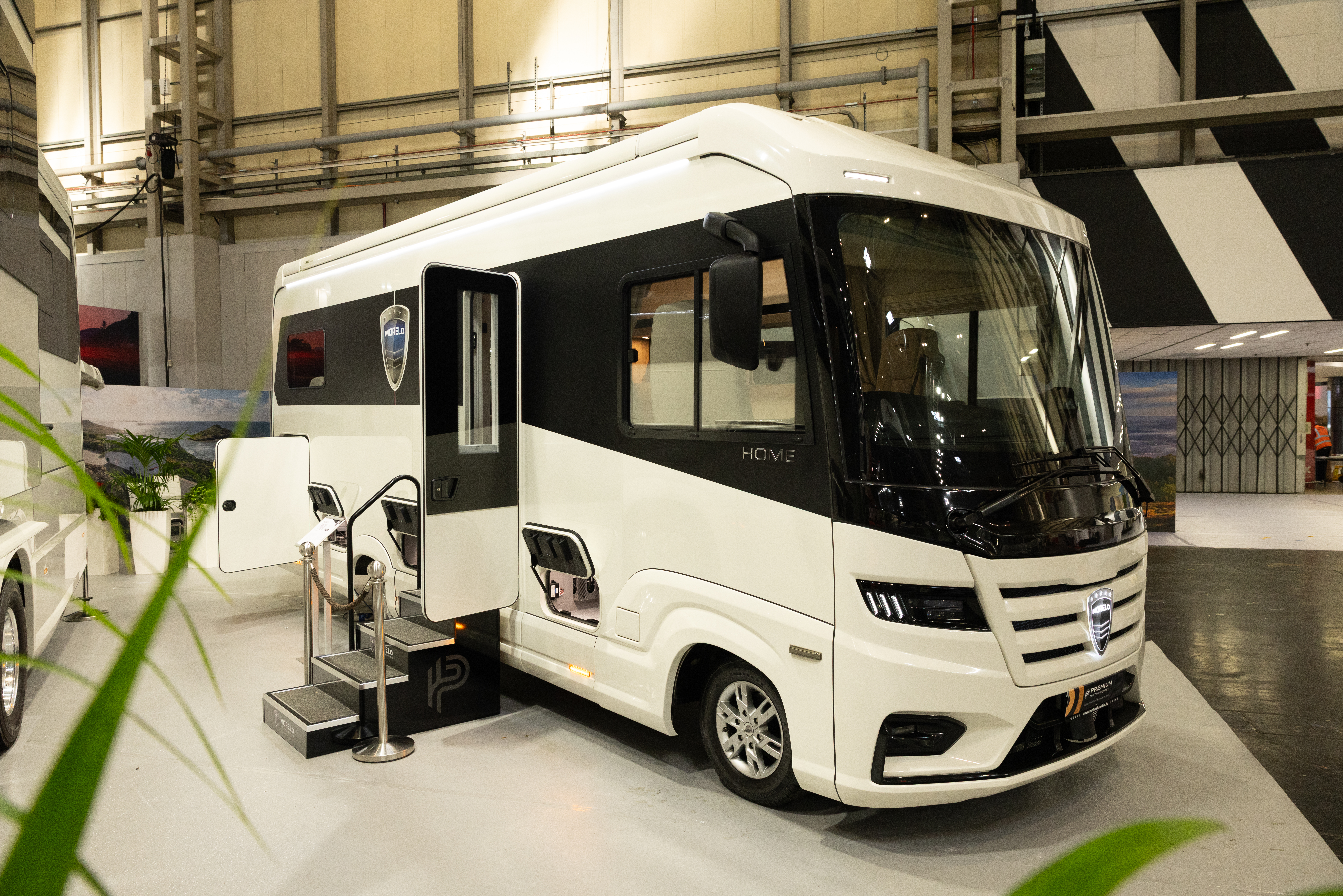 The MORELO HOME 78L has a black and white exterior.  Its habitation door is open and there are three steps to gain easy access.  The rear garage locker is open