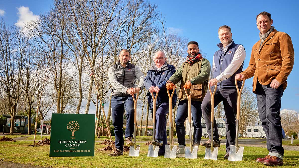 Five men standing with shovels