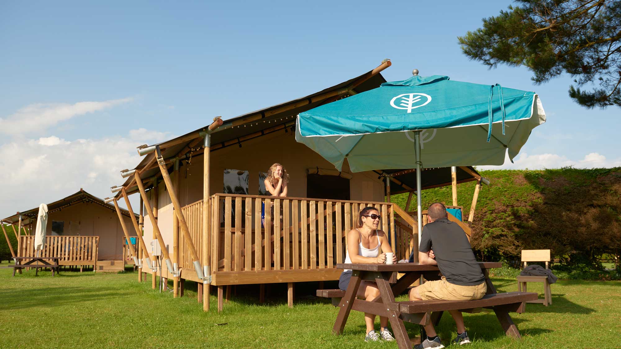 Family enjoying the sun outside a safari tent at Southland