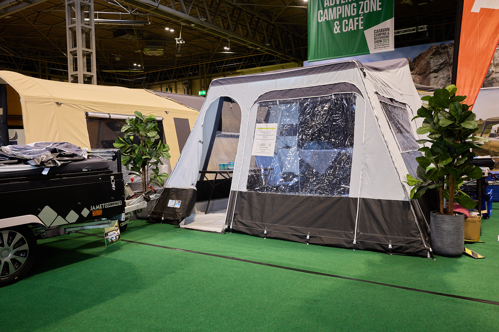 The Jamet Compact Eco has a grey and brown canvas.  The door is open revealing the interior.  The folded unit, in black, is to the left.