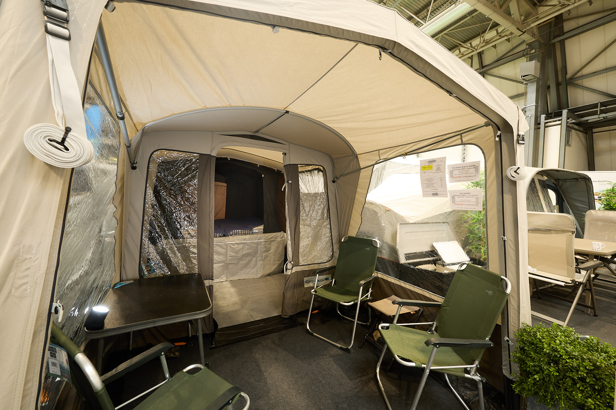 Campmaster AIR 600 LX interior, cream and brown canvas, showing the porch with four lime green chairs, the sleeping area is shown.