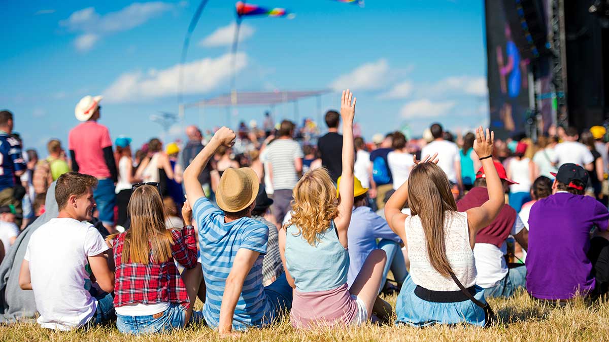 people sat on grass at a music festival
