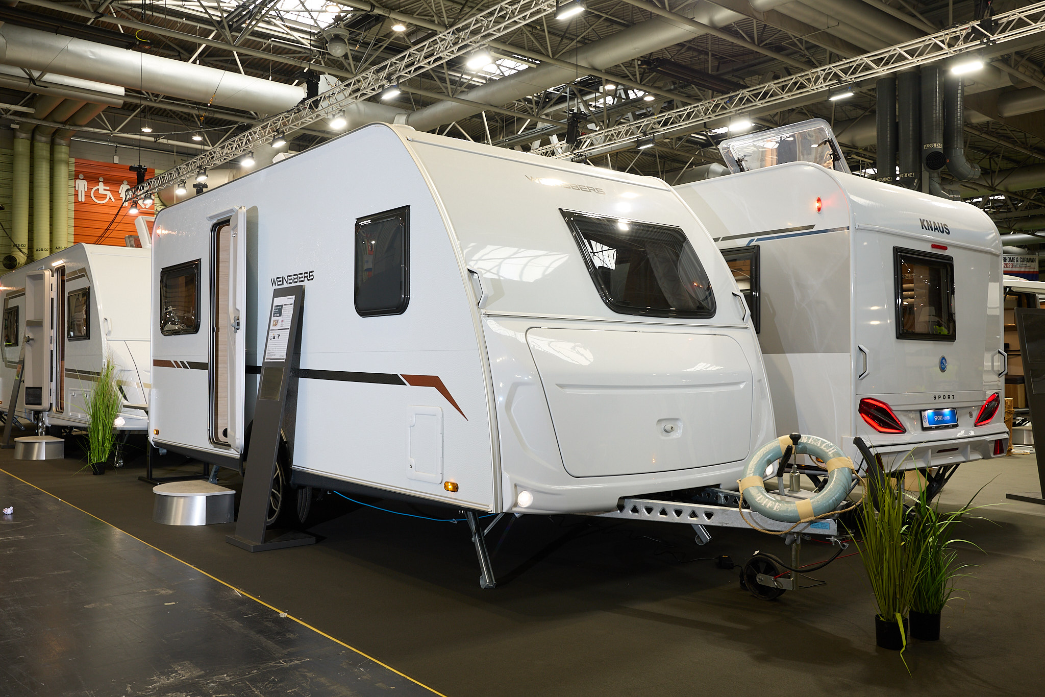 Weinsberg CaraCito 450 FU's exterior is white with an offside front window.  The door is open and there is a step to enable easy access to the interior.