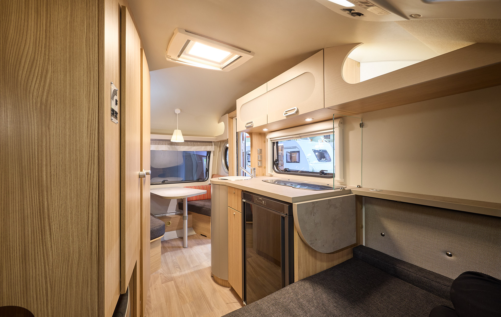 T@B 400's interior is primarily wooden with dark grey upholstery.  There is an extension to the work surface over the bed.