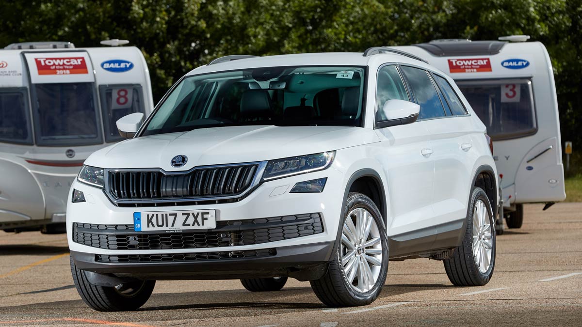 White 4x4 Skoda parked in front of two caravans