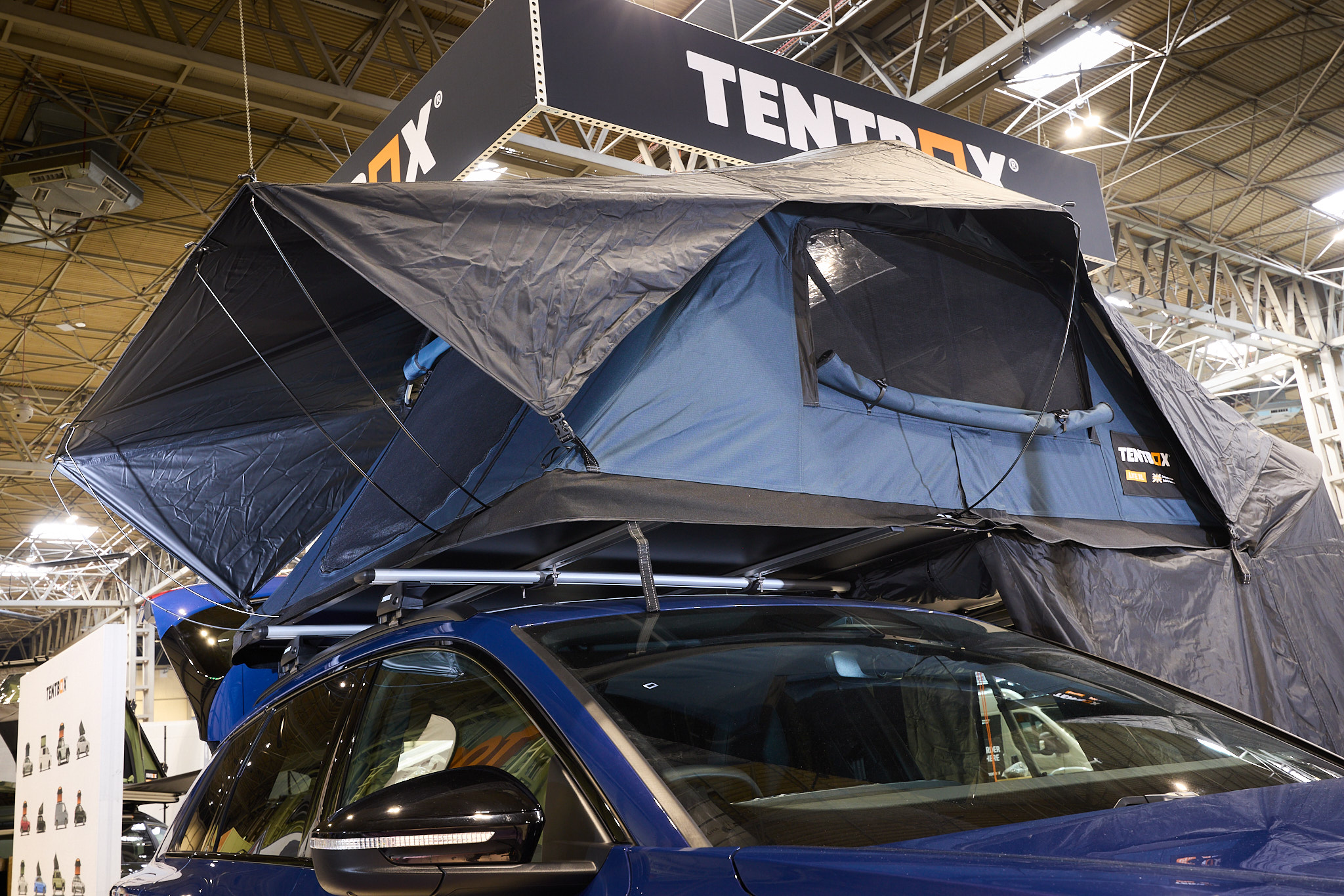 TentBox Lite XL has blue and black canvas.  It has an extension.  It is shown on a blue Audi. 