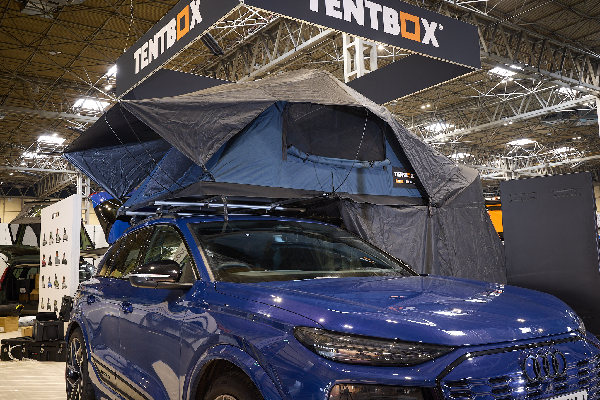 TentBox Lite XL has blue and black canvas.  It has an extension.  It is shown on a blue Audi. 